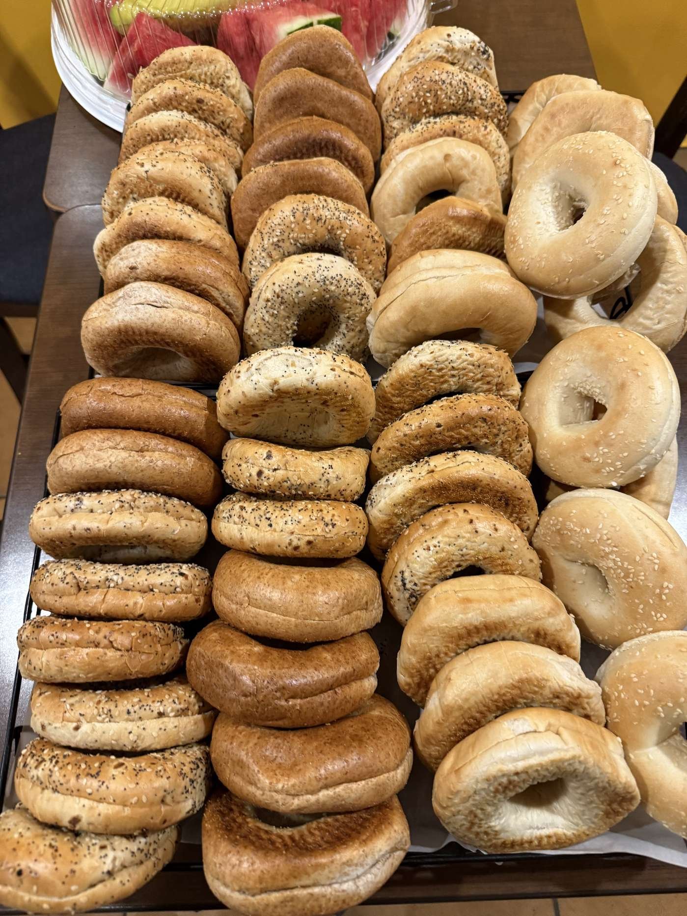 Assorted fresh bagels with cream cheese on a serving tray