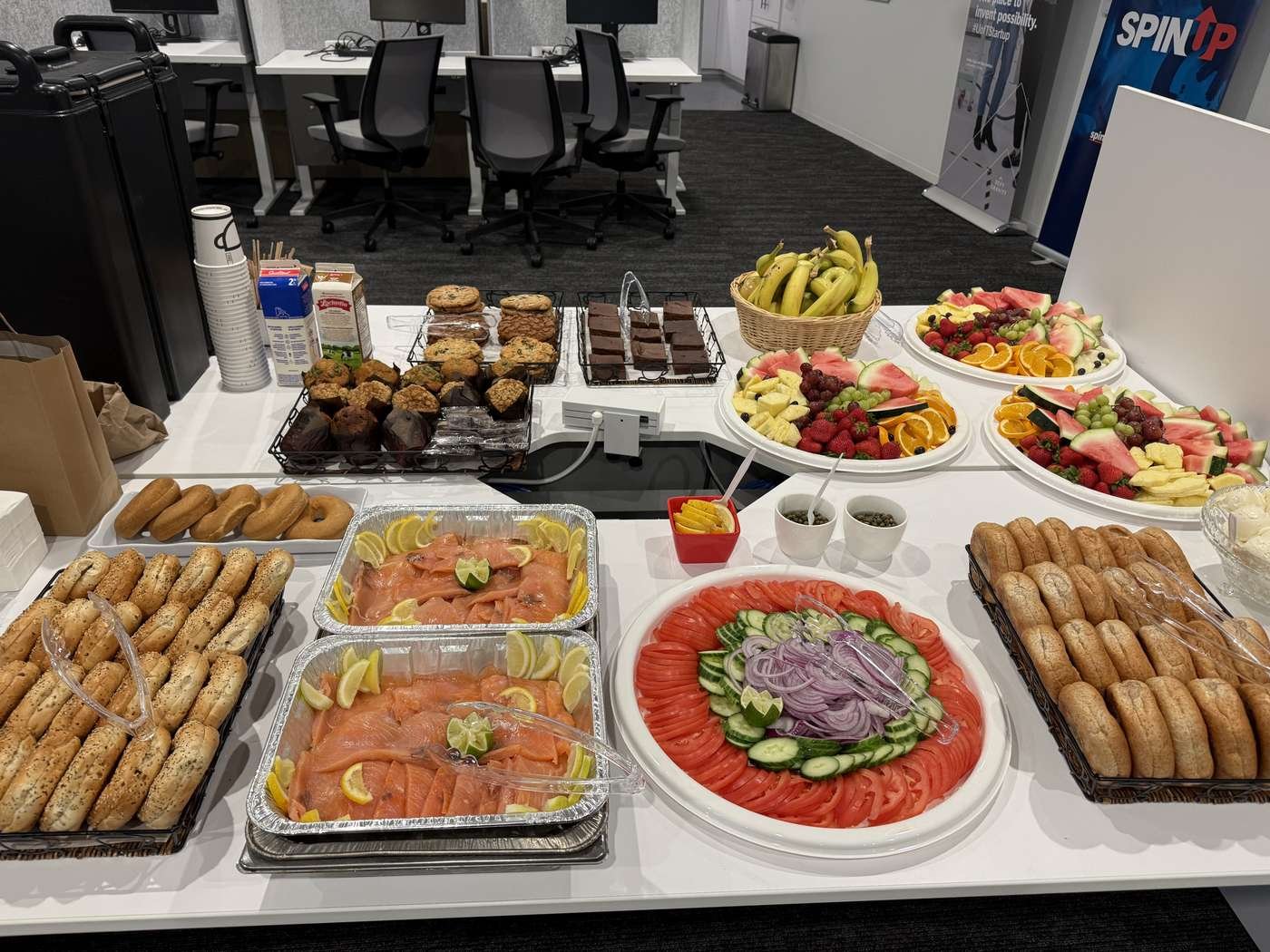 Boardroom table set with catering trays, plates and lunch platters